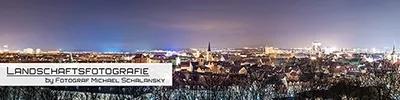 Panoramische Landschaftsaufnahme von Erfurt bei Nacht mit erleuchteter Stadtkulisse und markanten Kirchtürmen unter dem Nachthimmel. Fotografie von Michael Schalansky.
