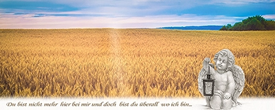 Engelsskulptur mit Laterne am Rand eines goldenen Kornfeldes unter weitem Himmel. Symbolisiert Trost und Gedenken. Bestattungsfotografie von Michael Schalansky.