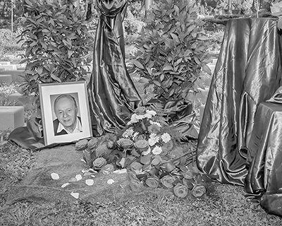 Schwarz-Weiß-Bild: Angehöriger bei einfühlsamer Urnenbestattung.