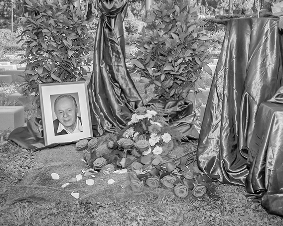 Schwarz-Weiß-Bild: Angehöriger bei einfühlsamer Urnenbestattung.