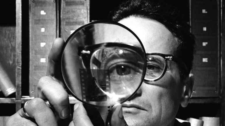 Selbstporträt von Andreas Feininger mit Lupe und Negativstreifen als Bezug zur fotografischen Haltung