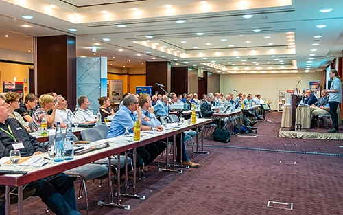 Firmenkonferenz im Dorint Hotel Weimar mit Redner am Podium und aufmerksamem Publikum.