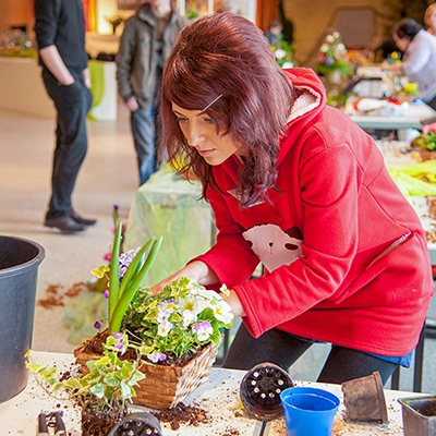 Floristin gestaltet ein Blumengesteck bei einem Wettbewerb in Erfurt.
