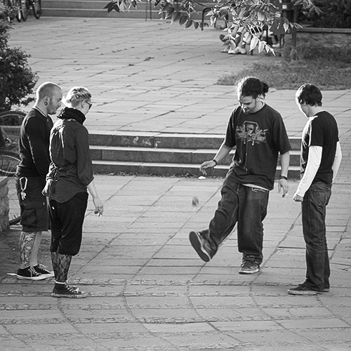 Vier junge Menschen spielen Hacky Sack auf einem Platz in Erfurt – dokumentarische Schwarz-Weiß-Eventfotografie.