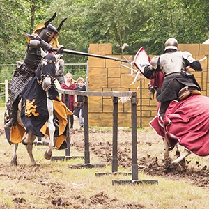 Zwei Ritter auf Pferden beim Lanzenstechen während eines Mittelalterfests in Bückeburg, umgeben von Zuschauern.