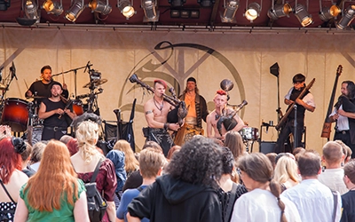 Saltatio Mortis live auf der Bühne beim MPS Bückeburg mit Dudelsäcken und Bandlogo im Hintergrund.