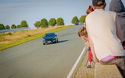 Viertelmeilenrennen: Hyundai beschleunigt auf der Rennstrecke, Zuschauer am Streckenrand