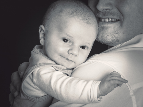 Kleinkindaufnahme auf Arm des Vaters in schwarz / weiß
