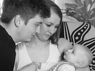Schwarz-weiß Familienporträt – Mutter und Vater schauen ihr Baby liebevoll an – Familienfotografie Erfurt