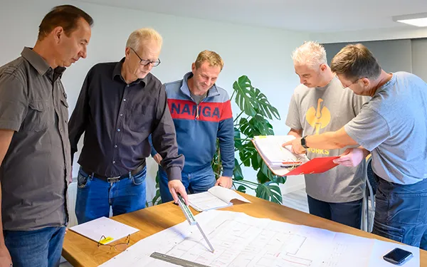 Planungsbesprechung im Unternehmen mit Bauplänen – Businessfotografie von Michael Schalansky aus Erfurt.