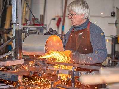 Industriefotografie in Erfurt: Metallbearbeitung mit Trennschneider und intensivem Funkenflug in einer Werkstatt in Thüringen.