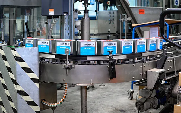 Produktionsanlage mit STAUFEN Aceton Kanistern auf Förderband – Industriefotografie von Michael Schalansky in Thüringen.