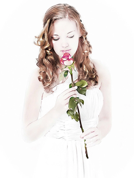 Romantische_Braut_Rose_Gefühlvolles_Portraet Nahaufnahme einer jungen Braut mit gewelltem Haar und trägerlosem Kleid, die ihre Augen geschlossen hält und sanft an einer einzelnen rot-weißen Rose riecht. Das Bild ist vor einem hellen, verschwommenen Hintergrund aufgenommen und vermittelt eine romantische und sinnliche Atmosphäre. Ein gefühlvolles Brautporträt von Hochzeitsfotograf Michael Schalansky.