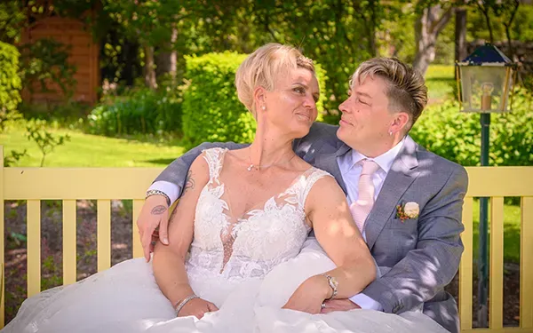 Hochzeitsfotografie in Erfurt und Thüringen: Brautpaar sitzt entspannt auf einer Gartenbank und schaut sich verliebt an – fotografiert von Michael Schalansky.