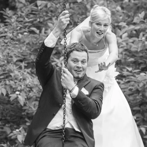 Schwarz-Weiß-Hochzeitsfoto in Erfurt und Thüringen: Brautpaar hat Spaß auf einer Schaukel, ungestellter Moment voller Energie – Michael Schalansky.