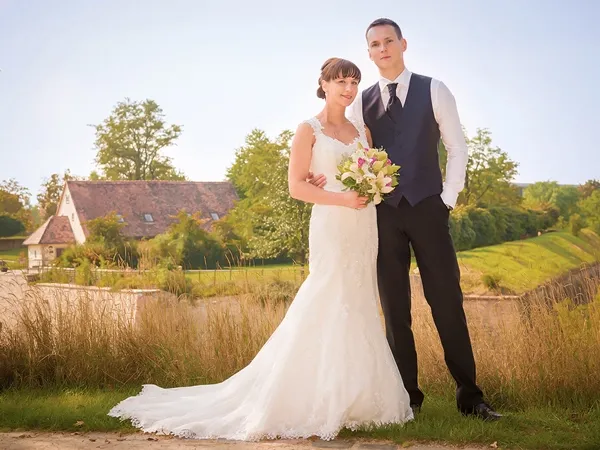 Hochzeitsfoto in Erfurt am Petersberg: Brautpaar steht in natürlicher Landschaft mit Brautstrauß, warmes Abendlicht – Hochzeitsfotografie von Michael Schalansky.