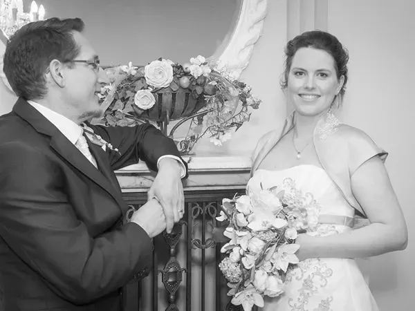 Klassisches Schwarz-Weiß-Hochzeitsfoto: Brautpaar vor einem eleganten Kamin mit Blumendekor – Hochzeitsfotografie von Michael Schalansky in Erfurt und Thüringen.