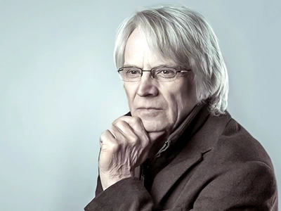 Hochwertiges Porträt eines älteren, weisen Mannes mit grauem Haar und Brille, der eine nachdenkliche Pose einnimmt, fotografiert von Michael Schalansky.