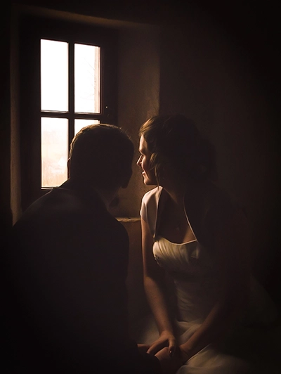 Romantisches Hochzeitsporträt eines Brautpaares im Gegenlicht am Fenster – stimmungsvolle Silhouette