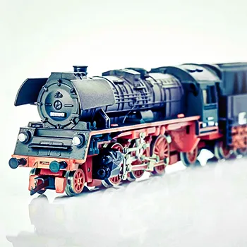 Originale Produktaufnahme einer TT-Modellbahn-Dampflokomotive auf einer transparenten Plexiglasplatte vor weißem Hintergrund.